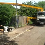 Truck-mounted boom pump pouring conctete over the top of tall trees