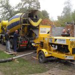 Trailer-mounted pump transporting ready-mix concrete through a static line