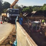 SCHWING 24m concrete boom pump — pumping down from road to construction site