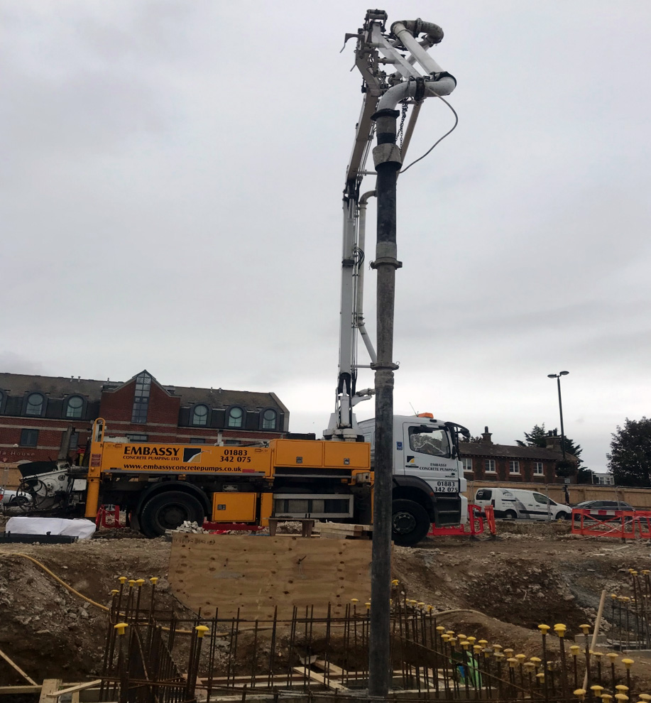 View of boom pumping concrete down into building site