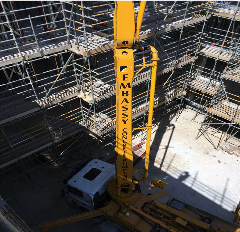 View of concrete boom pump at floor level from top floor of building